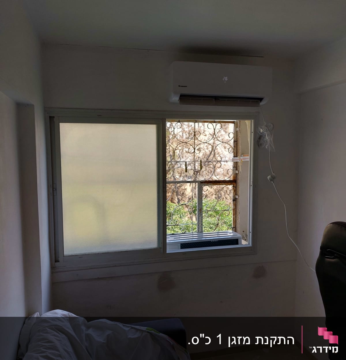 מזגן מותקן מעל חלון בחדר